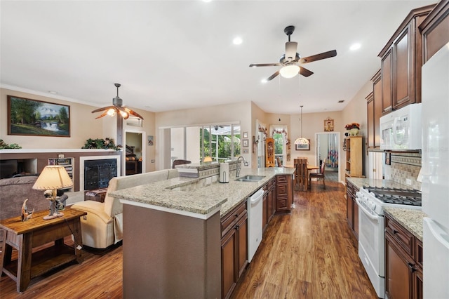 kitchen featuring light hardwood / wood-style floors, a kitchen island with sink, sink, appliances with stainless steel finishes, and ceiling fan