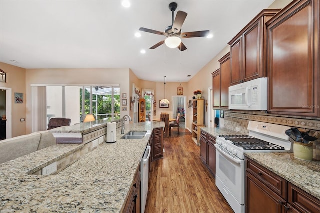 kitchen featuring light stone counters, light hardwood / wood-style floors, sink, white appliances, and ceiling fan