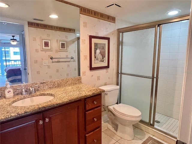 bathroom with ceiling fan, vanity, toilet, walk in shower, and tile patterned flooring