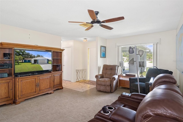 tiled living room with ceiling fan and a textured ceiling