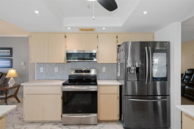 kitchen featuring appliances with stainless steel finishes, light brown cabinetry, ceiling fan, and tasteful backsplash