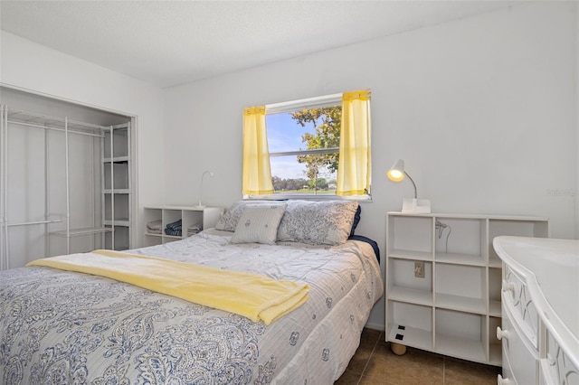 tiled bedroom with a textured ceiling and a closet