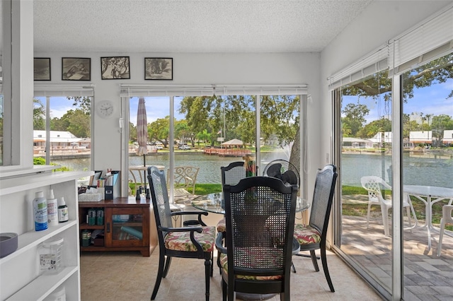 sunroom featuring a water view