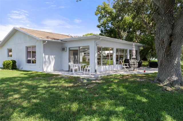 rear view of house featuring a lawn, a patio, and an AC wall unit