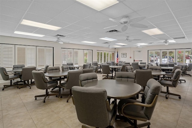 tiled dining area featuring a paneled ceiling, ceiling fan, and a wealth of natural light