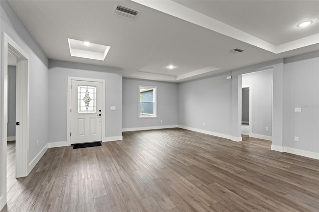 foyer featuring a tray ceiling and hardwood / wood-style flooring