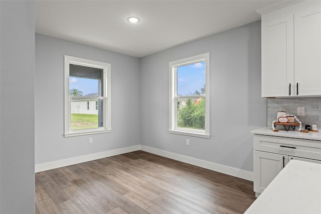 unfurnished dining area featuring light wood-type flooring