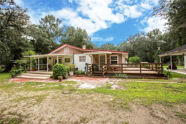 rear view of house with covered porch and a yard