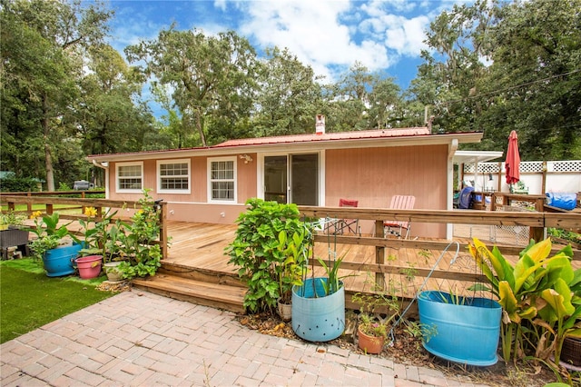 back of house with a wooden deck and a patio area