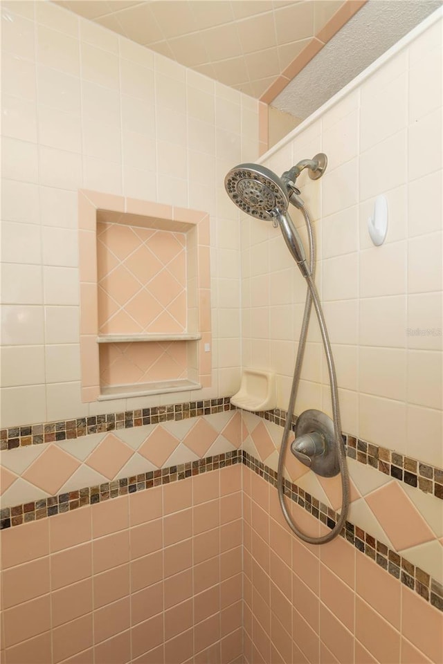 interior details featuring a tile shower