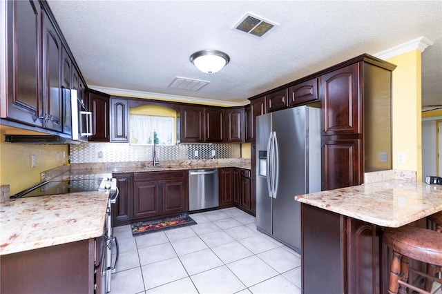 kitchen with kitchen peninsula, a breakfast bar area, stainless steel appliances, ornamental molding, and sink