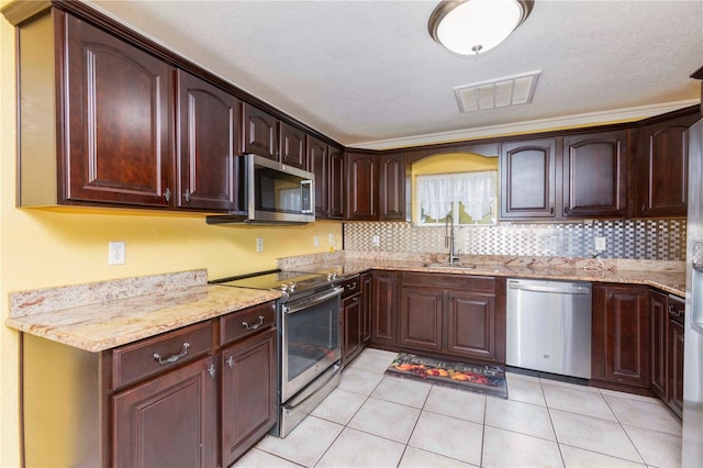 kitchen with light stone counters, sink, decorative backsplash, appliances with stainless steel finishes, and light tile patterned floors