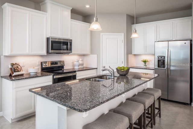 kitchen featuring white cabinets, an island with sink, and stainless steel appliances