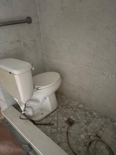 bathroom featuring tile walls, toilet, and tile patterned floors