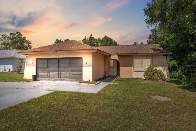 view of front of home with a yard and a garage