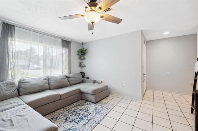 tiled living room with a textured ceiling and ceiling fan