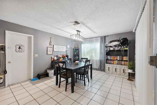 tiled dining space with a chandelier and a textured ceiling