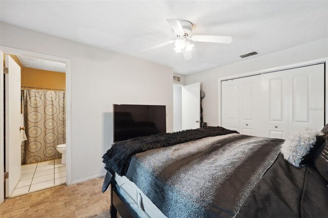 bedroom with a textured ceiling, connected bathroom, ceiling fan, and a closet