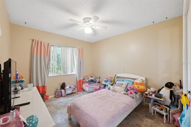 bedroom with ceiling fan and a textured ceiling