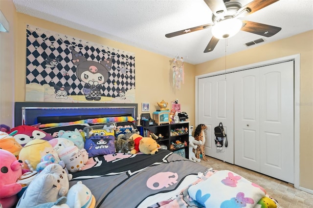 bedroom with a textured ceiling, ceiling fan, and a closet