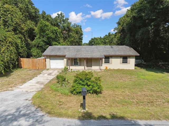 single story home featuring a front lawn and a garage