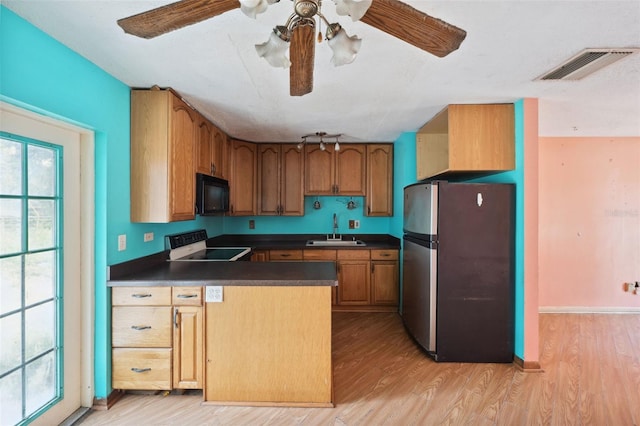 kitchen featuring ceiling fan, sink, stainless steel refrigerator, electric stove, and light hardwood / wood-style floors