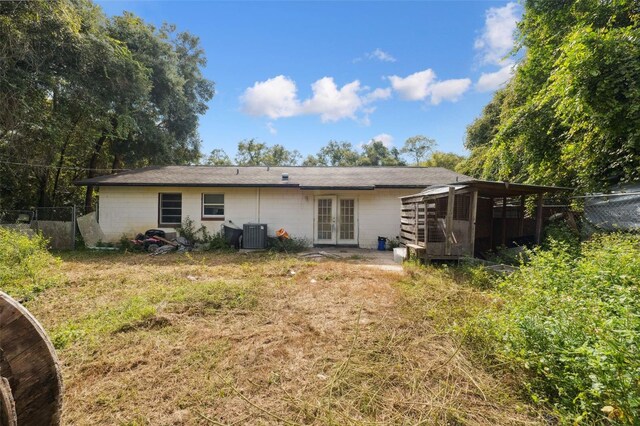 365 S Snapp Ave, Inverness, FL 34453 - rear view of house with central air condition unit, fence, concrete block siding, and french doors