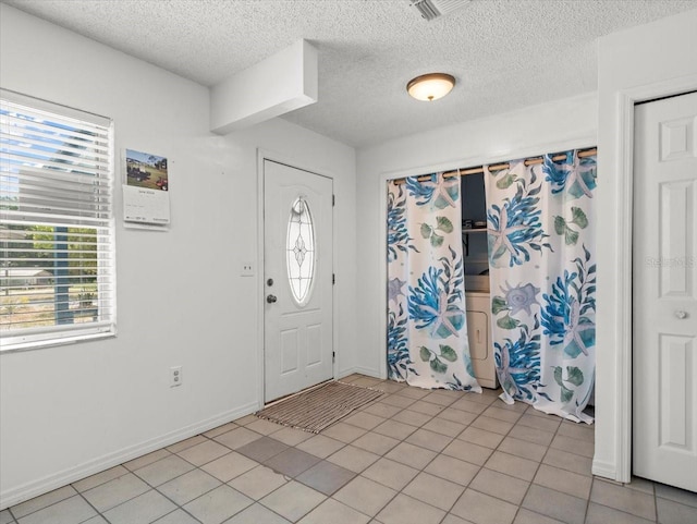 tiled foyer featuring a textured ceiling