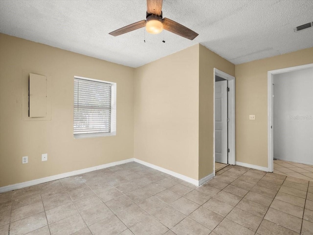 tiled spare room with ceiling fan and a textured ceiling