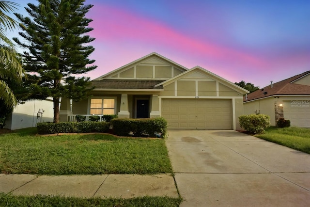 view of front of house with a yard, a porch, and a garage