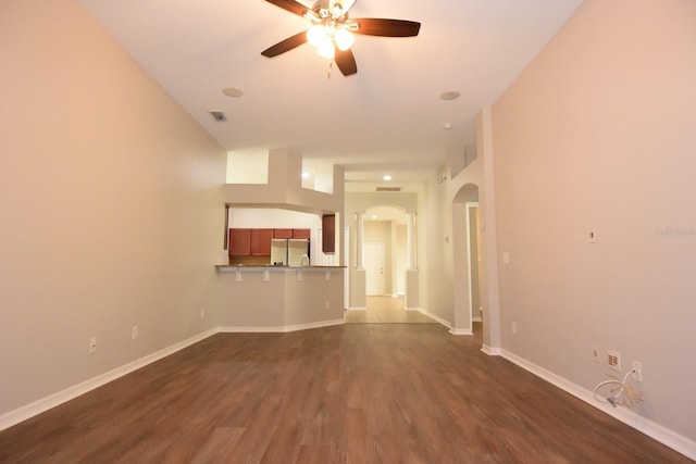 unfurnished living room featuring dark hardwood / wood-style flooring and ceiling fan