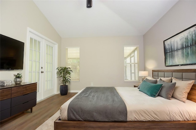 bedroom with french doors, vaulted ceiling, and hardwood / wood-style floors