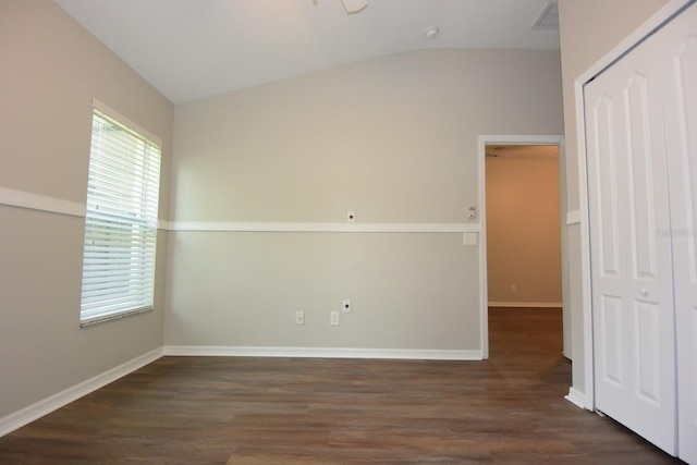 empty room with vaulted ceiling and dark hardwood / wood-style flooring