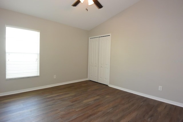 unfurnished bedroom featuring multiple windows, ceiling fan, vaulted ceiling, and dark hardwood / wood-style floors