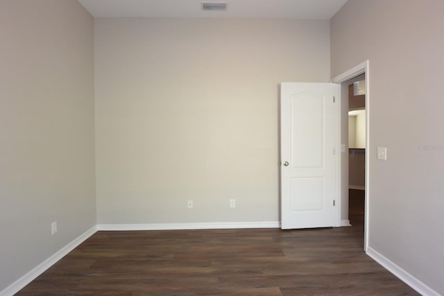 unfurnished room with dark hardwood / wood-style flooring