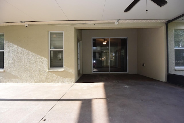 view of exterior entry featuring a patio and ceiling fan