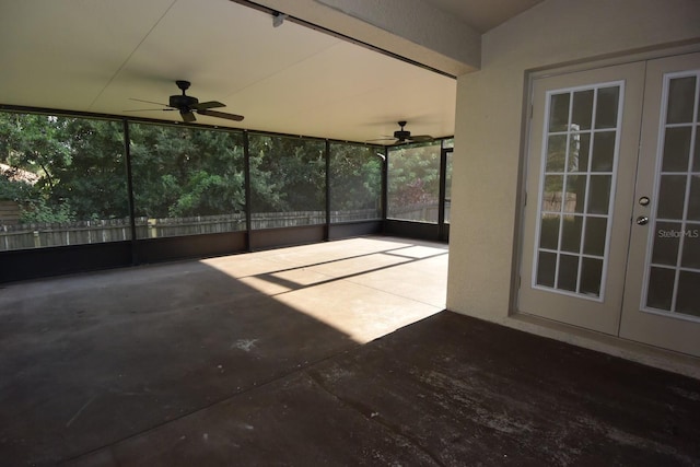 unfurnished sunroom featuring ceiling fan and french doors