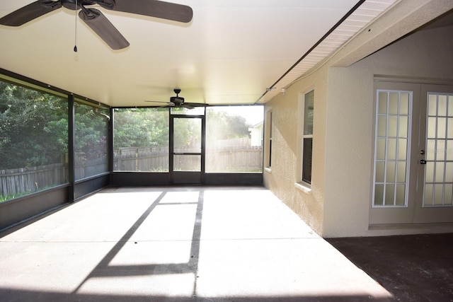 unfurnished sunroom featuring ceiling fan and french doors