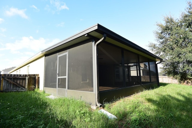 view of side of property with a yard and a sunroom