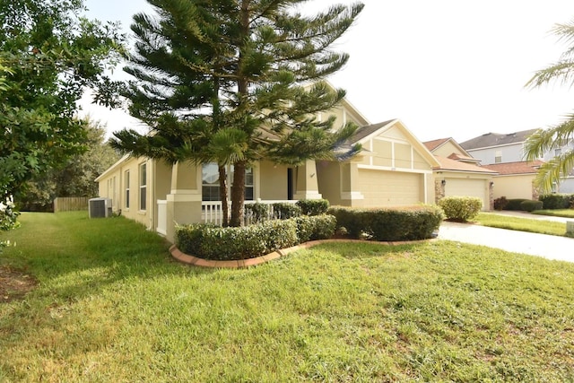 view of front of home with a garage, central AC unit, and a front yard