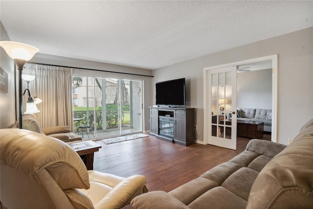 living room featuring a textured ceiling and dark wood-type flooring