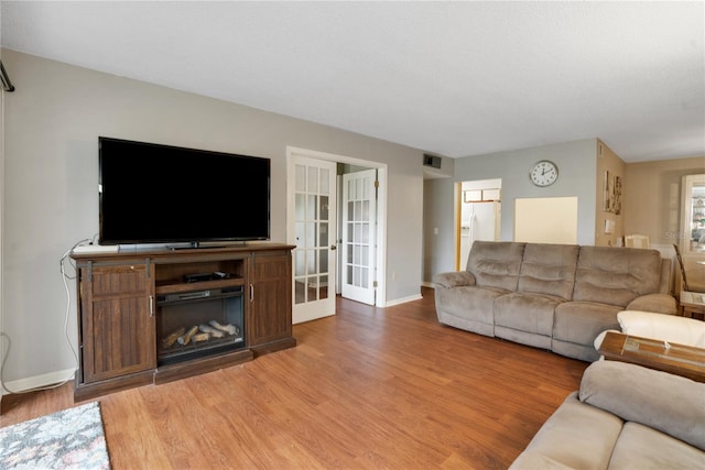 living room with french doors and hardwood / wood-style flooring