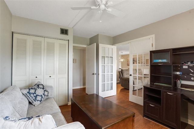 office with french doors, a textured ceiling, dark wood-type flooring, and ceiling fan