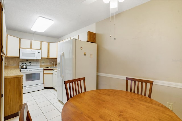 kitchen with ceiling fan, sink, white appliances, backsplash, and white cabinetry