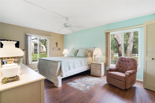 bedroom with multiple windows, dark hardwood / wood-style floors, and ceiling fan