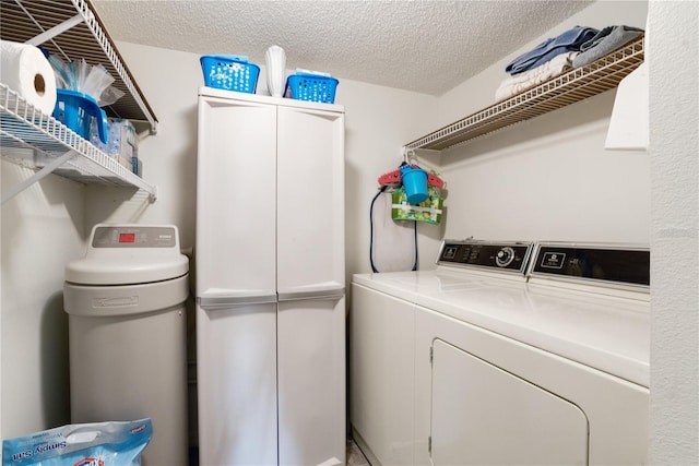 laundry room with a textured ceiling and washing machine and clothes dryer