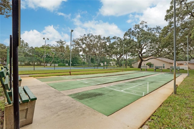 view of home's community featuring tennis court