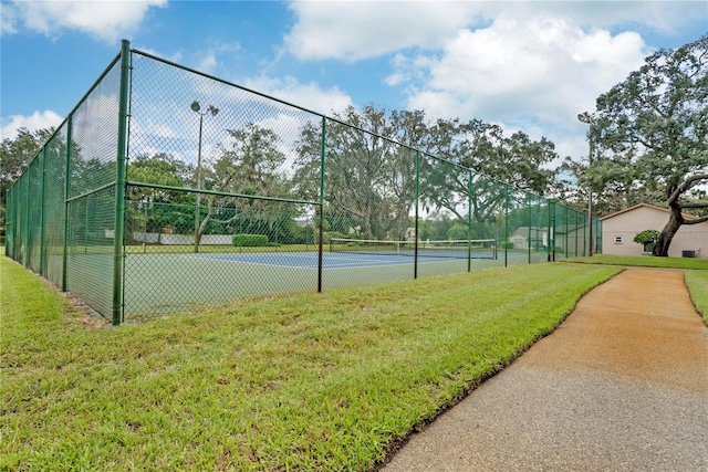 view of tennis court with a lawn