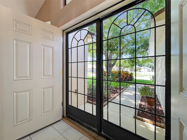 doorway to outside with lofted ceiling and light tile patterned floors