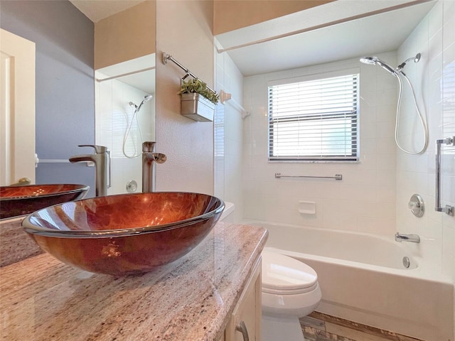 full bathroom with toilet, tiled shower / bath combo, vanity, and hardwood / wood-style floors